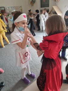 Dzieci przebranych w różne postaci bawią si e na balu karnawałowym.