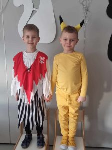 Dwóch chłopców przebranych w stroje karnawałowe pozuje do zdjęcia.