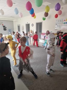 Dzieci przebranych w różne postaci bawią si e na balu karnawałowym.