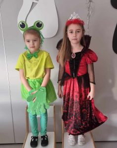 Dwie dziewczynki przebrane w stroje karnawałowe pozują do zdjęcia.