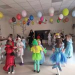 Dzieci przebranych w różne postaci bawią si e na balu karnawałowym.