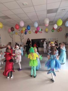 Dzieci przebranych w różne postaci bawią si e na balu karnawałowym.