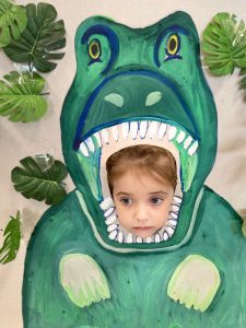 Dziewczynka w fotobudce dinozaura
