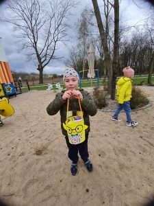 CHŁOPIEC TRZYMA KOSZYCZEK W RĄCZCEW RĄ