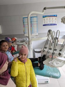 DZIEWCZYNKA TRZYMAJĄCA SZCZYPCE DENTYSTYCZNE