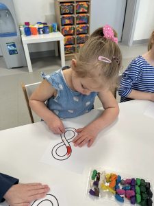 DZIECI WYKONUJĄ PRACED PLASTYCZNE ZE ZNAKIEM NIESKOŃCZONOŚCI