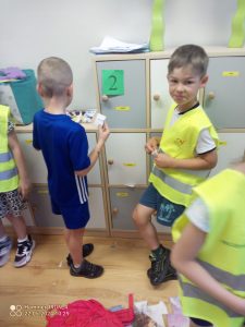 Dzieci pokazują w rękach cyfry, które odnalazły w szkolnej klasie.