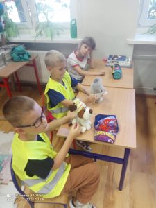 Dzieci siedzą w szkolnej ławce.