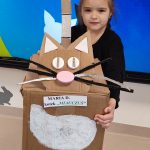 Dziecko pozuje ze swoim kotem wykonanym z różnorodnych odpadów - recyklingu.