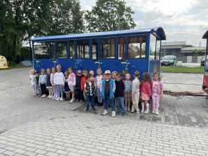 DZIECI POZUJĄ DO ZDJĘCIA NA TLE KOLEJKI