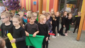 Dzieci ubrane na czarno oczekują na swój występ na festynie.