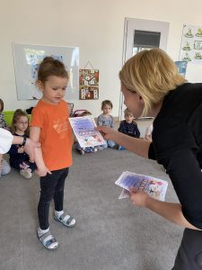Pani instruktor tańca wręcza dzieciom dyplomy "Super Tancerza"