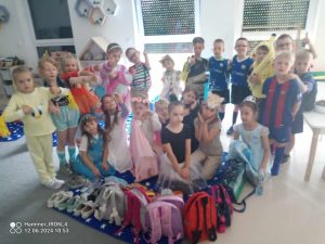 Duża grupa dzieci przebrani w różne stroje pozują do wspólnego zdjęcia.