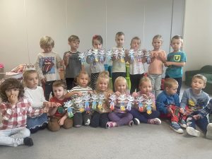 Chłopcy i dziewczynki trzymają wykonaną przez siebie prace