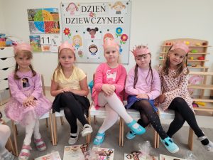 Dziewczynki siedzą na krzesłach i pozują do zdjęcia
