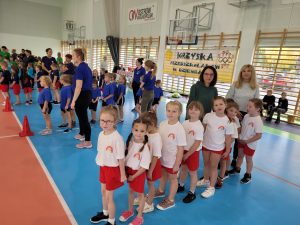 Dzieci z Paniami czekają na start w zawodach stojąc w rzędzie
