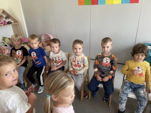 Chłopcy siedzą na krzesłach z orderami z okazji dnia chłopaka