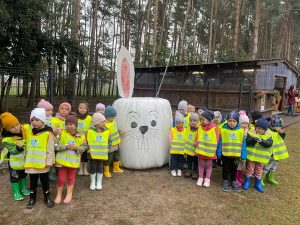 Dziewczynki i chłopcy stoją przy króliczku