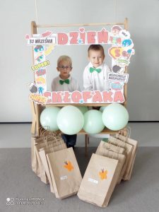 Chłopcy stoją przy fotobudce