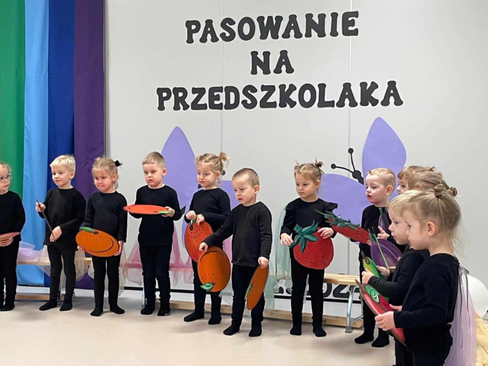 Dzieci trzymają owoce.