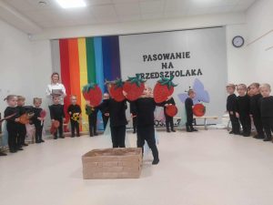 Dzieci wkładają owoce do kosza