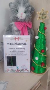 Dyplom z wyróżnieniem, choinka konkursowa oraz szary kot.