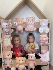 Dziewczynki trzymają misie w fotobudzce