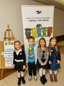 Czwórka dzieci stoi w holu OCK-u pozuje do zdjęcia