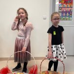 Dwie dziewczynki rozdają jabłka z koszyków