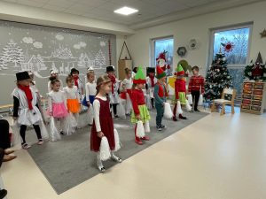 Cała grupa dzieci tańczy stojąc w szeregach