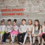 Dzieci siedzą na ławkach