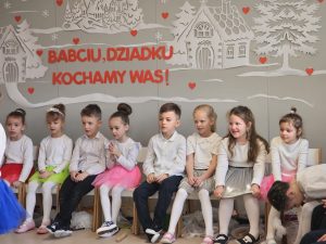 Dzieci siedzą na ławkach