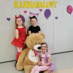 Trzy dziewczynki pozują do zdjęcia z misiem