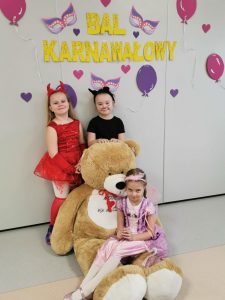 Trzy dziewczynki pozują do zdjęcia z misiem