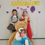 Trzy dziewczynki pozują do zdjęcia z misiem