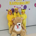 Trzy dziewczynki pozują do zdjęcia z misiem
