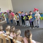 Chłopcy stoją i trzymają kwiaty zrobione z balonów.