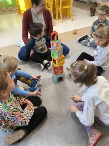 Dzieci i Panie układają wieżę z pudełek