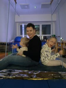 2 dzieci i pani na huśtawce- platformie