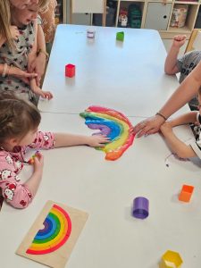 Dzieci tworzą kolorową tęczę z kolorowych slime.