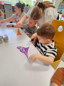 Dzieci bawią się kolorowymi slime.