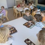 Dzieci dekorują czekoladę i dodają dodatki wybrane przeze siebie.