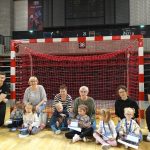 Sześcioro dzieci, cztery Panie i dwóch sportowców znajdujący się w hali sportowej.