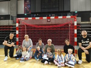 Sześcioro dzieci, cztery Panie i dwóch sportowców znajdujący się w hali sportowej.