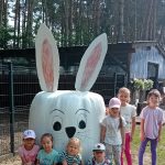 dzieci pozują do zdjęcia przy białym króliczku