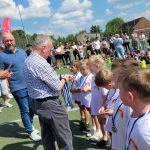 Sześcioro dzieci stojących w rzędzie, mający wręczane medale. Naprzeciwko stoi Pan Prezydent i mężczyzna wręczający medale.
