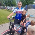 Dziewczynka siedząca na motorze, obok zaproszony gość