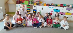 Grupa dzieci z instruktorem w białym kimono