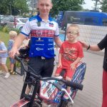 Chłopiec siedzący na motorze, obok zaproszony gość