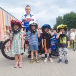 Czworo dzieci w żużlowych kaskach na głowie, razem z zaproszonym gościem.